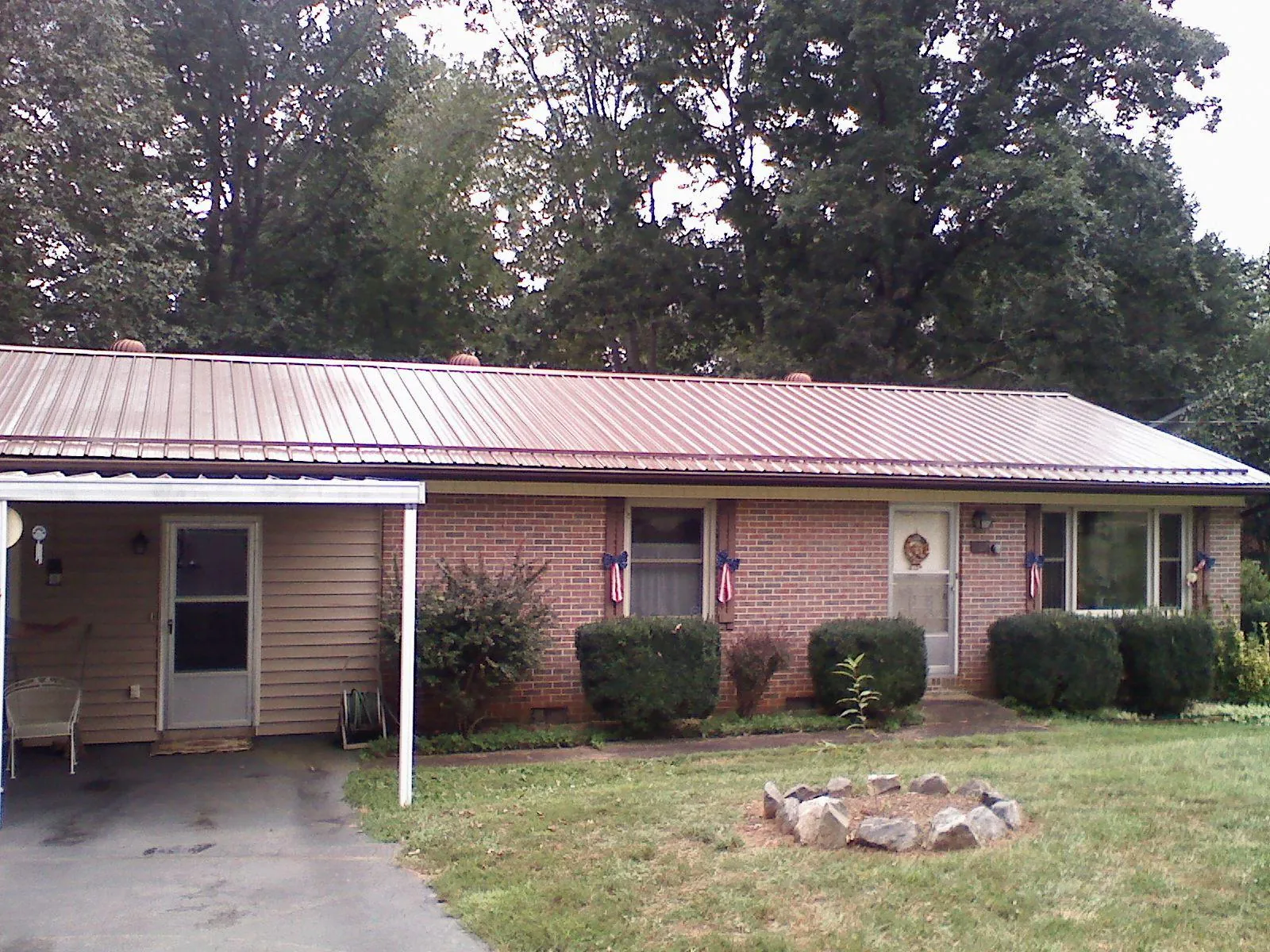 Bronze metal roof and carport on a brick ranch home — Roof Repair work by our crew in Easton